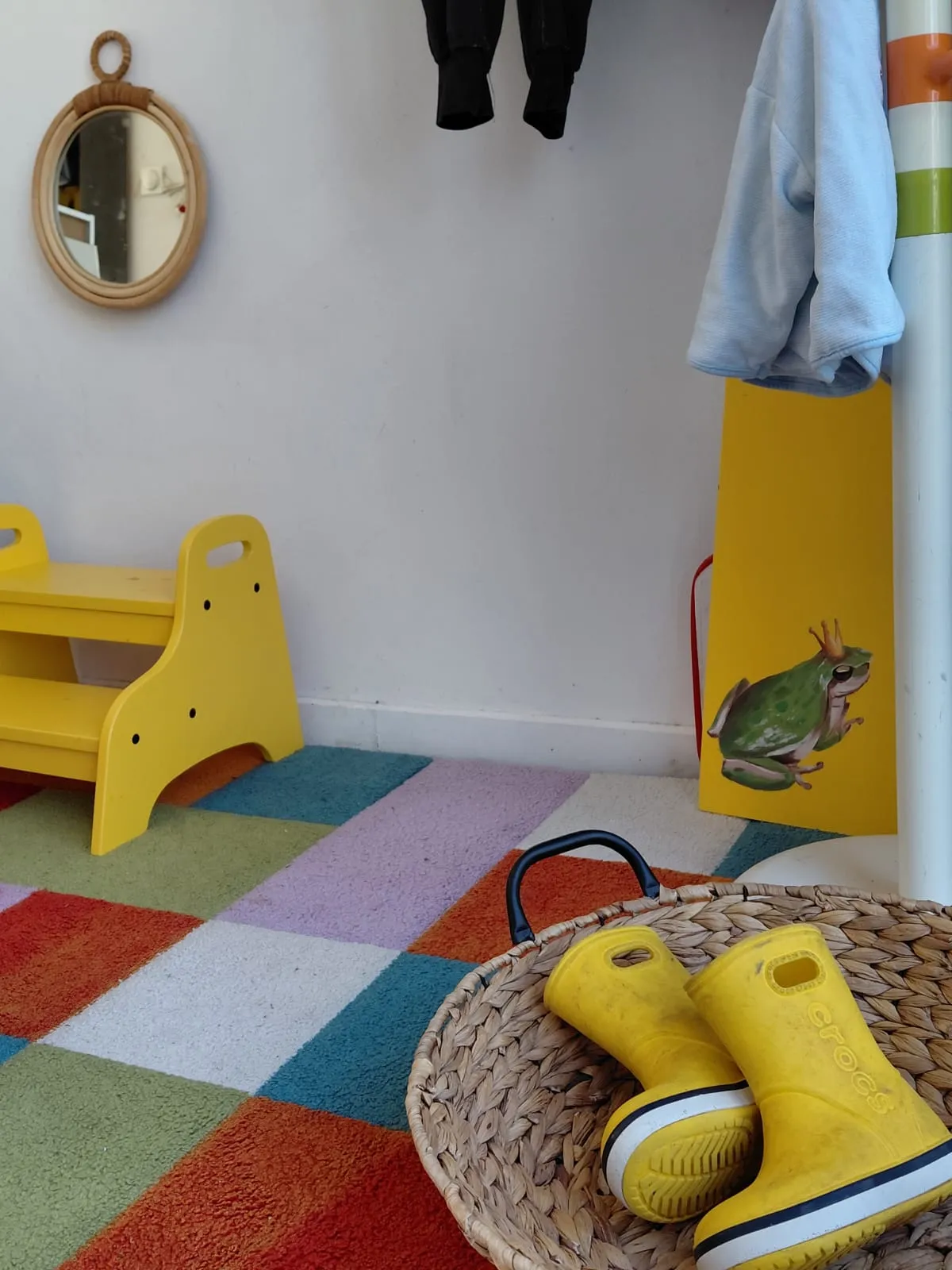 Entrée de L'Escargotière — tapis coloré, bottes dans un panier osier, autonomie dès l'accueil chez Sarah Poppins